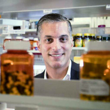 Shaun Noorian looking over a shelf of medication.