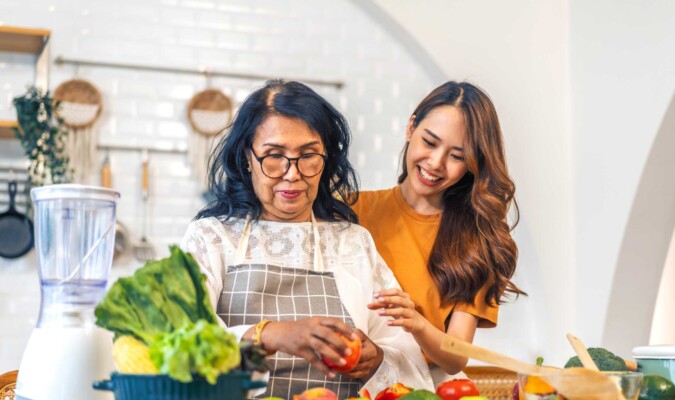 Two women preparing produce in the kitchen.