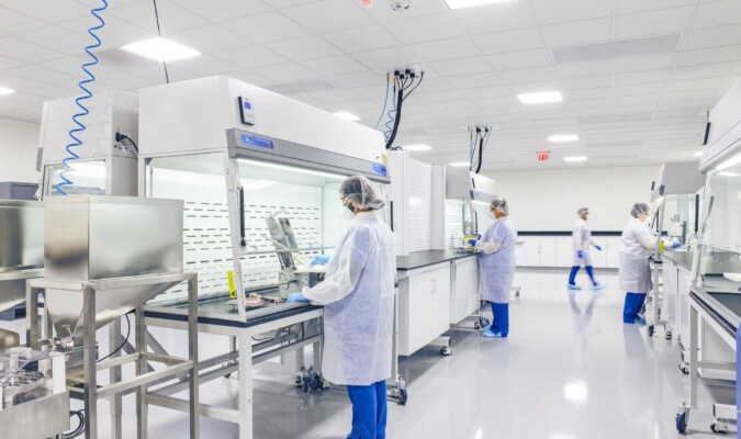 People in protective clothing working under a sterile hood.