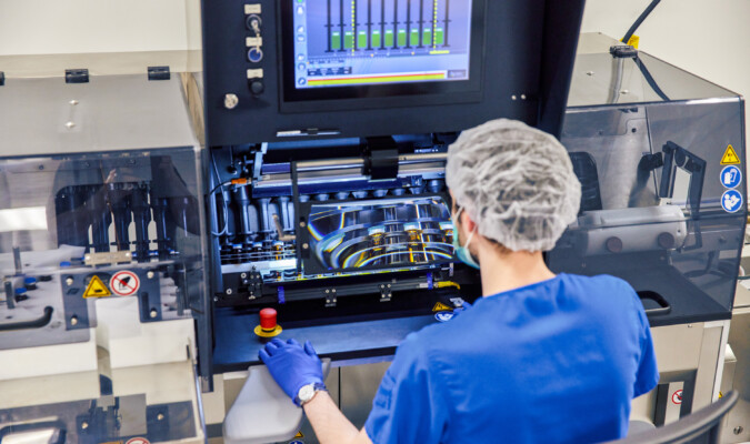 A person in blue scrubs operating machinery.